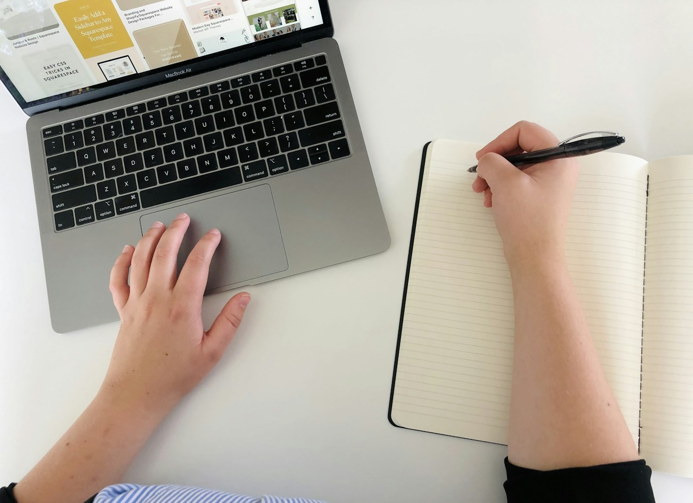 Prise de notes dans un carnet à côté d’un ordinateur portable